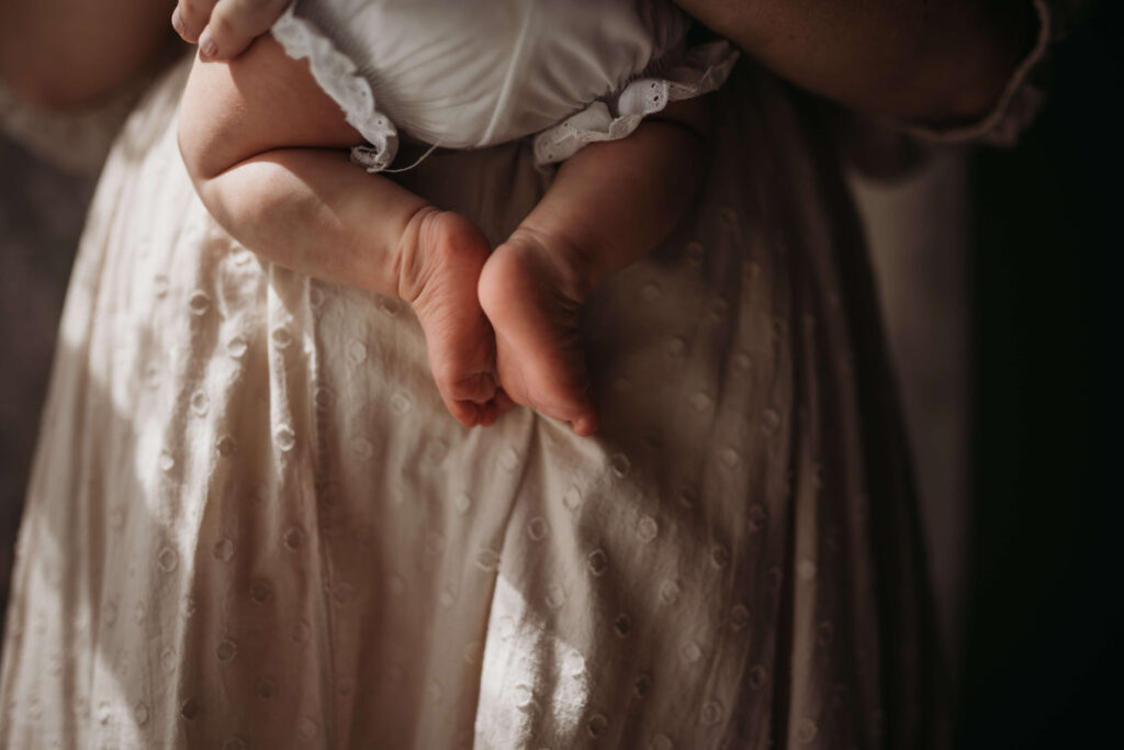 newborn baby feet against mothers tummy