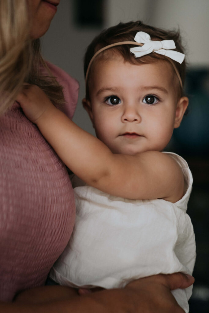 one year old daughter being held by mother during an in home photoshoot