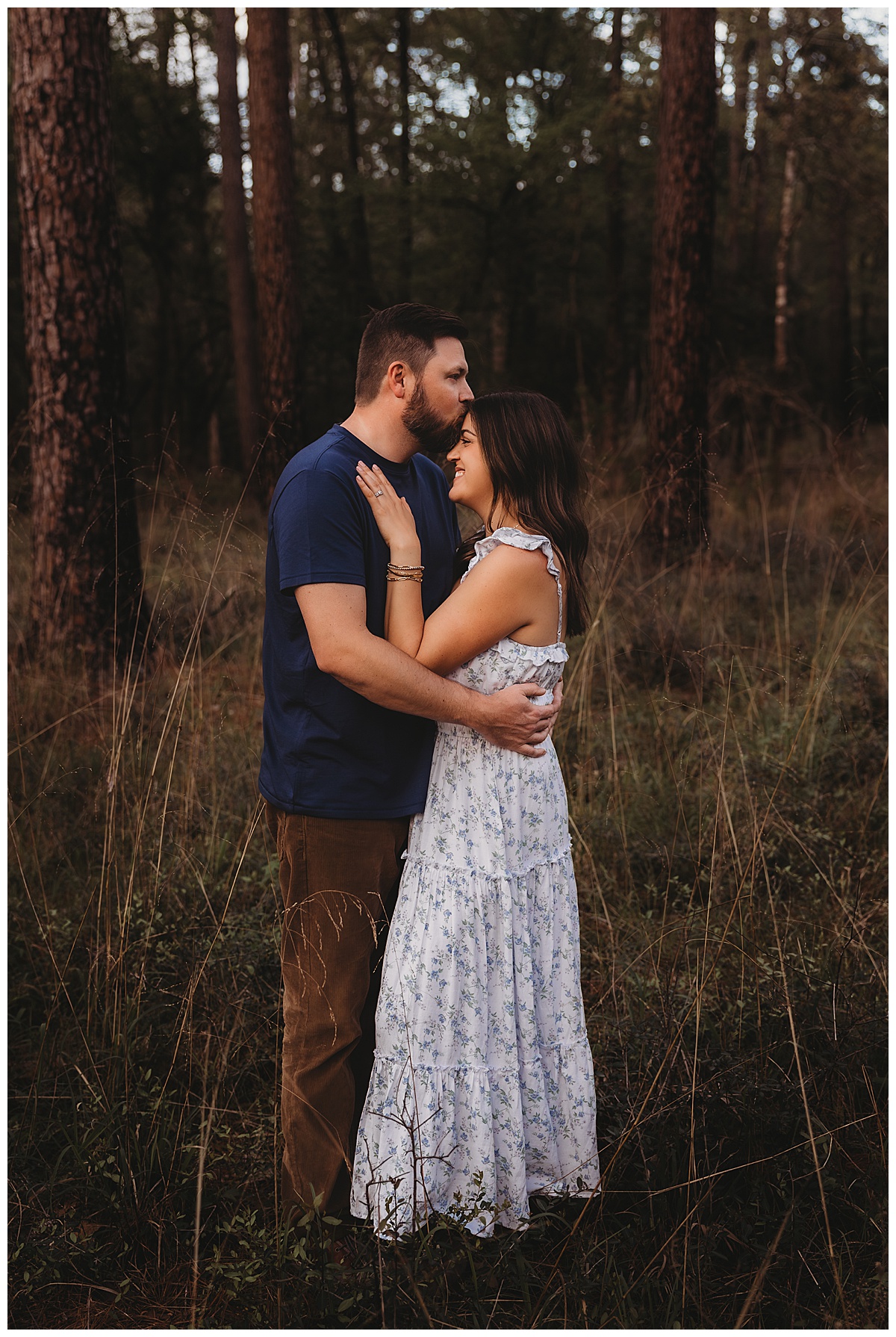 Parents hold each other close together and share a kiss by The Woodlands Family Photographer