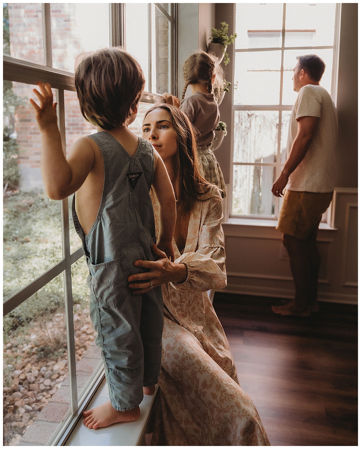 Family stand in front of windows for The Woodlands Family Photographer