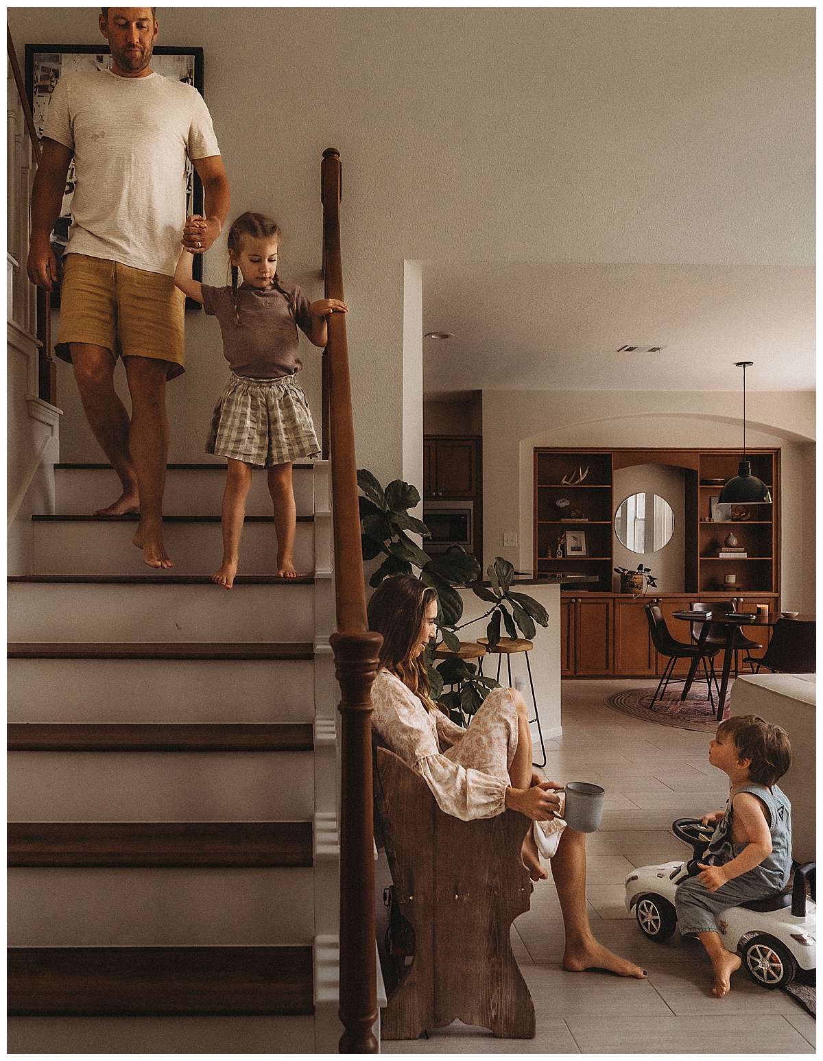 Dad and daughter walk down the stairs to mom and son for The Woodlands Family Photographer