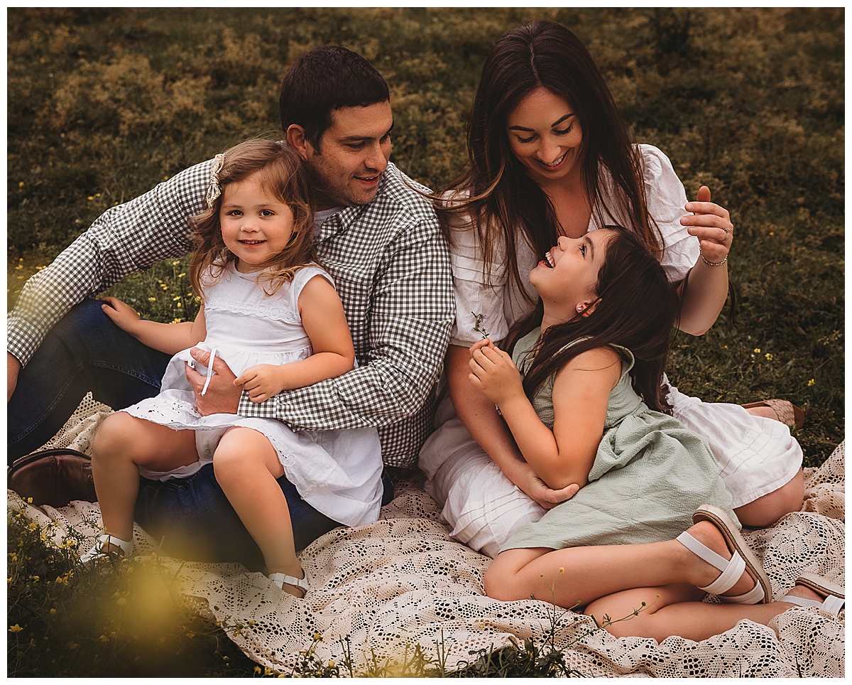 Family sit together on a lace blanket for Maria Grace Photos