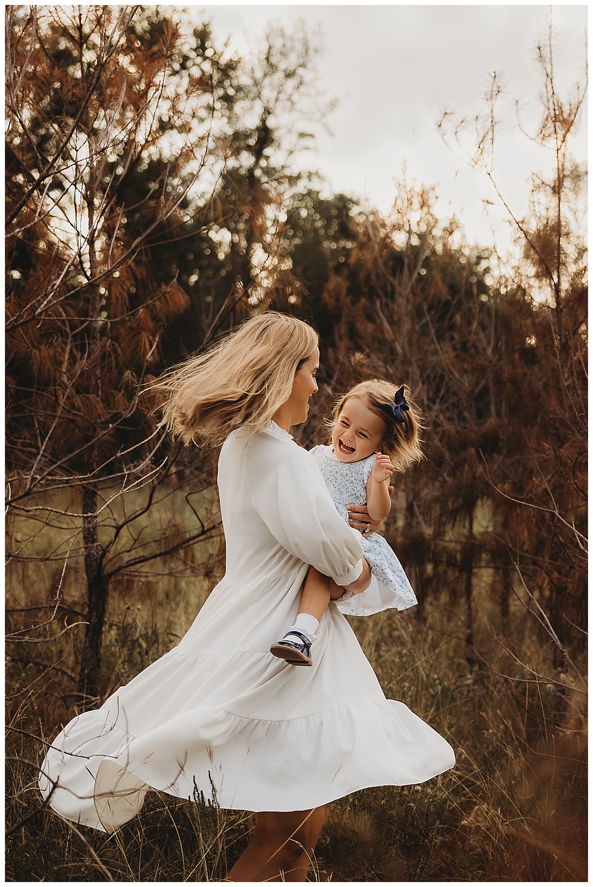 Mom and daughter laugh and dance together forThe Woodlands Family Photographer