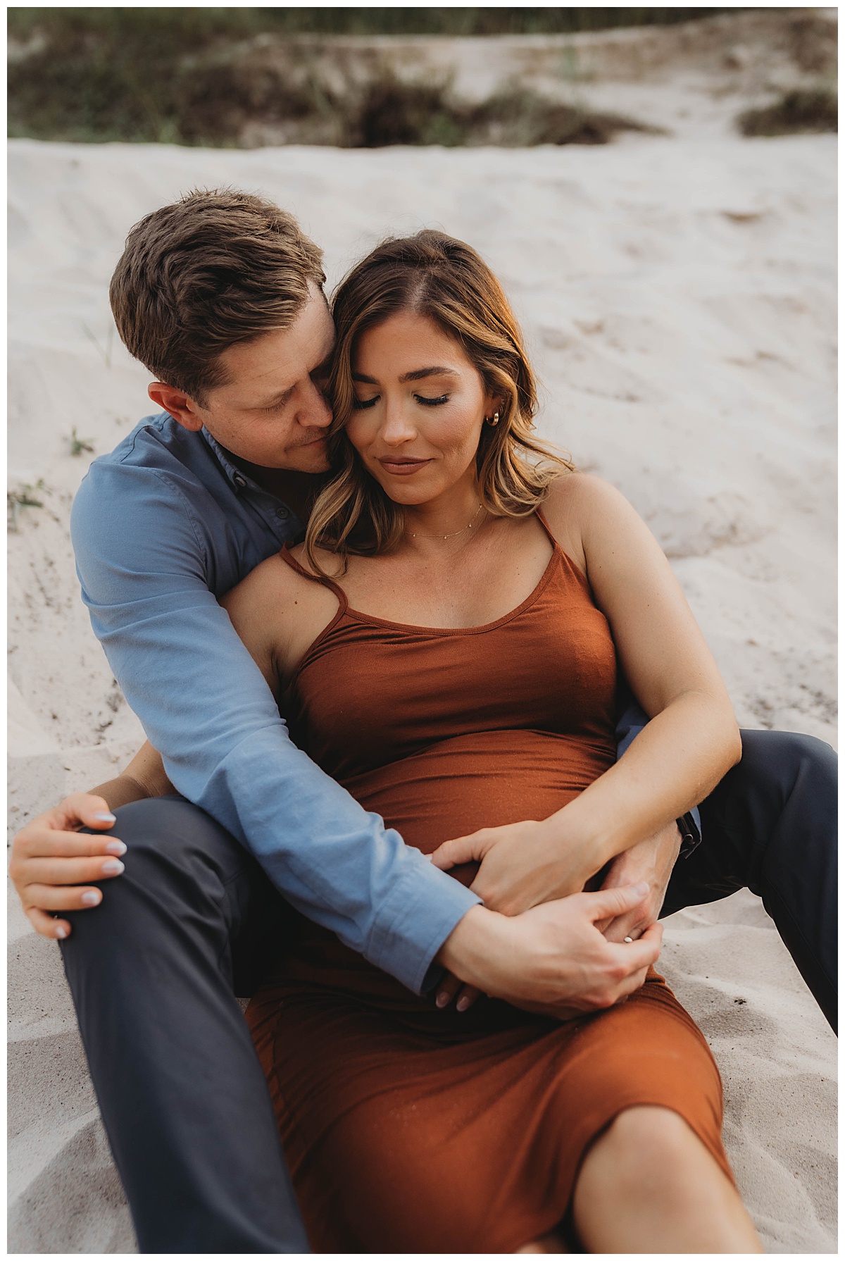 Parents sit together and embrace the baby bump by Maria Grace Photos