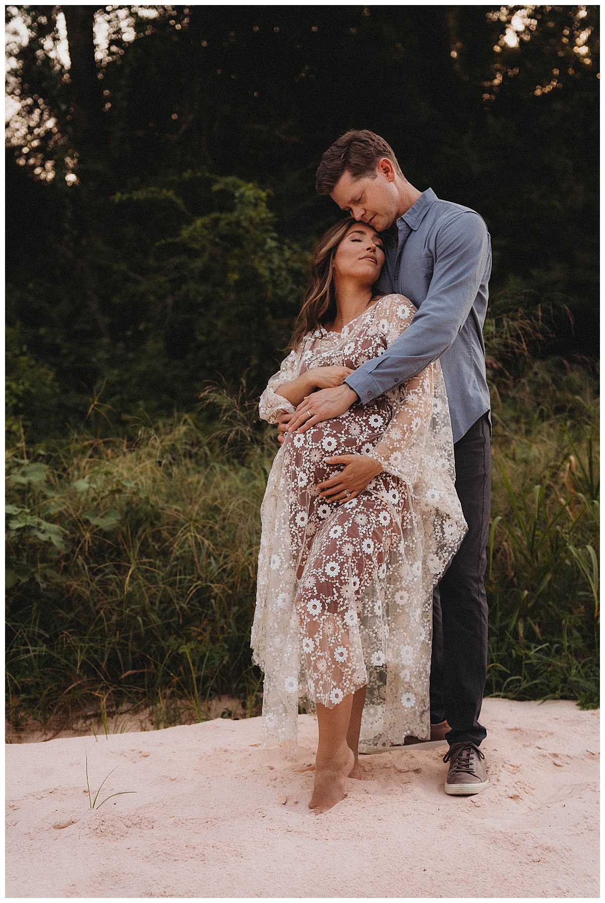 Mom and dad hold onto the baby bump by The Woodlands Family Photographer