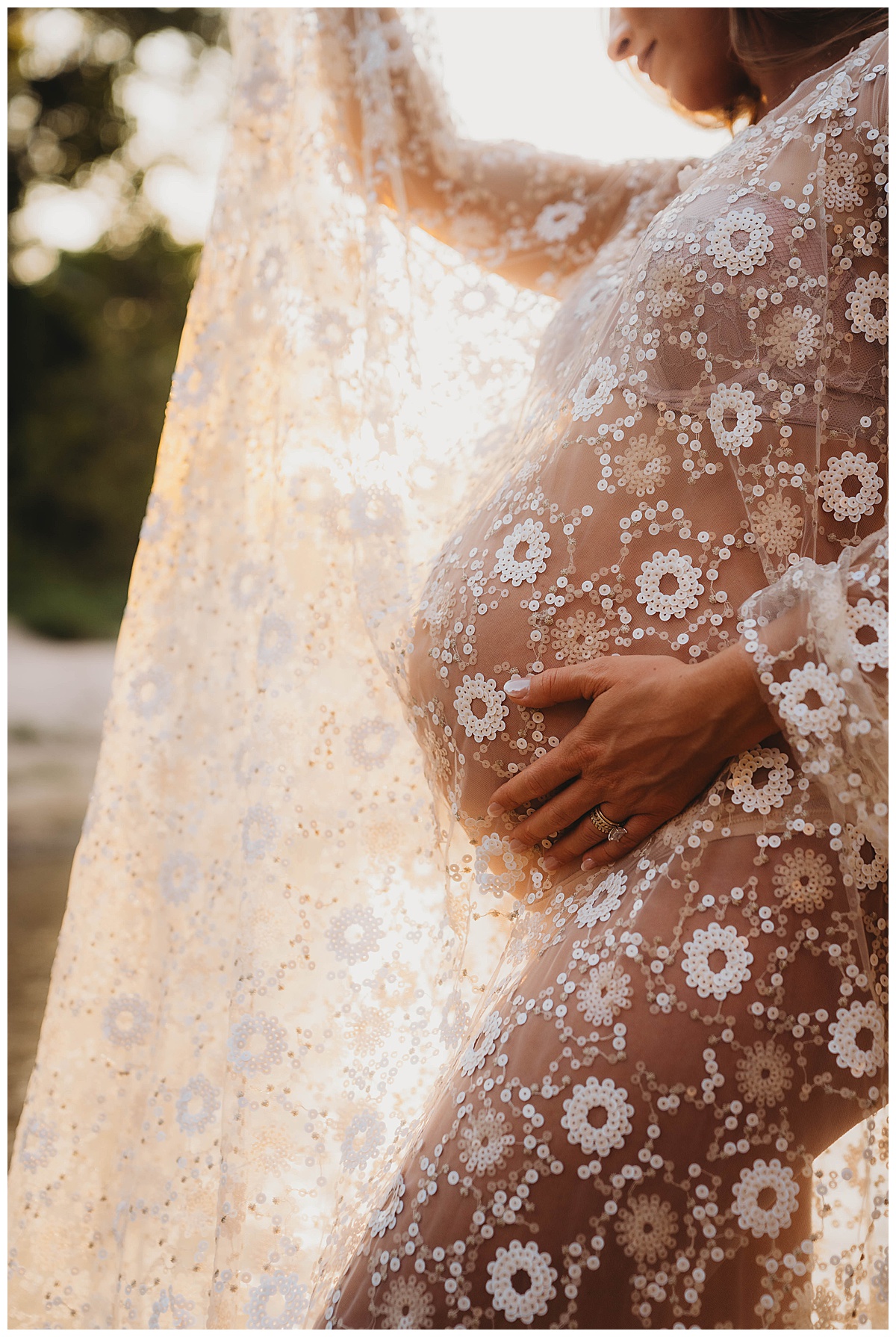 Female holds onto her baby bump by The Woodlands Family Photographer