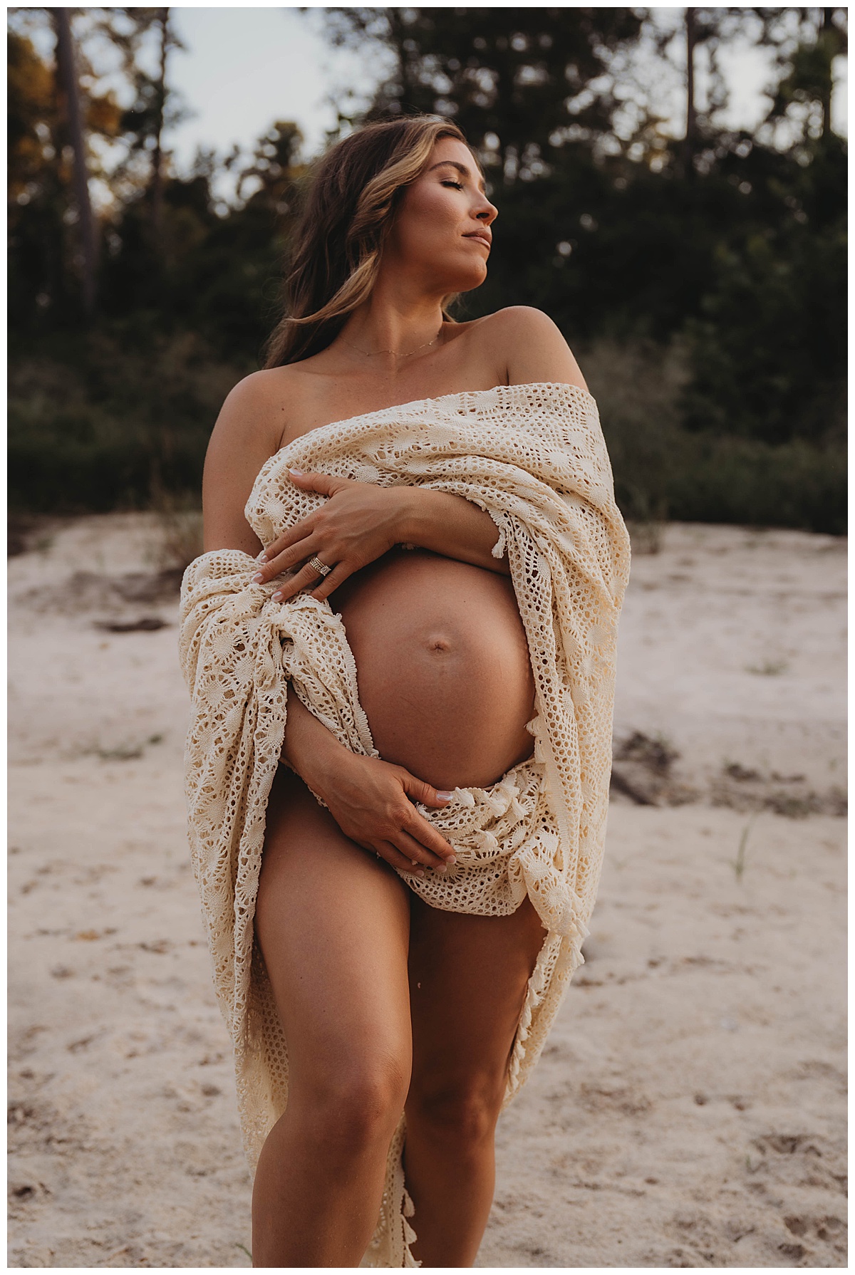 Mother shows off her pregnant belly by The Woodlands Family Photographer