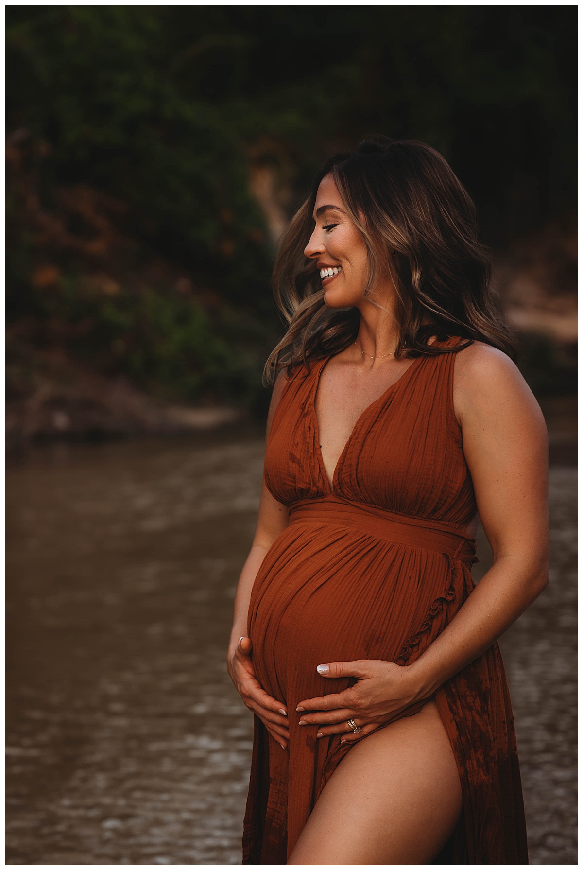 Mother shares a big smile while embracing her baby bump showing the Perfect Time for Maternity Photos