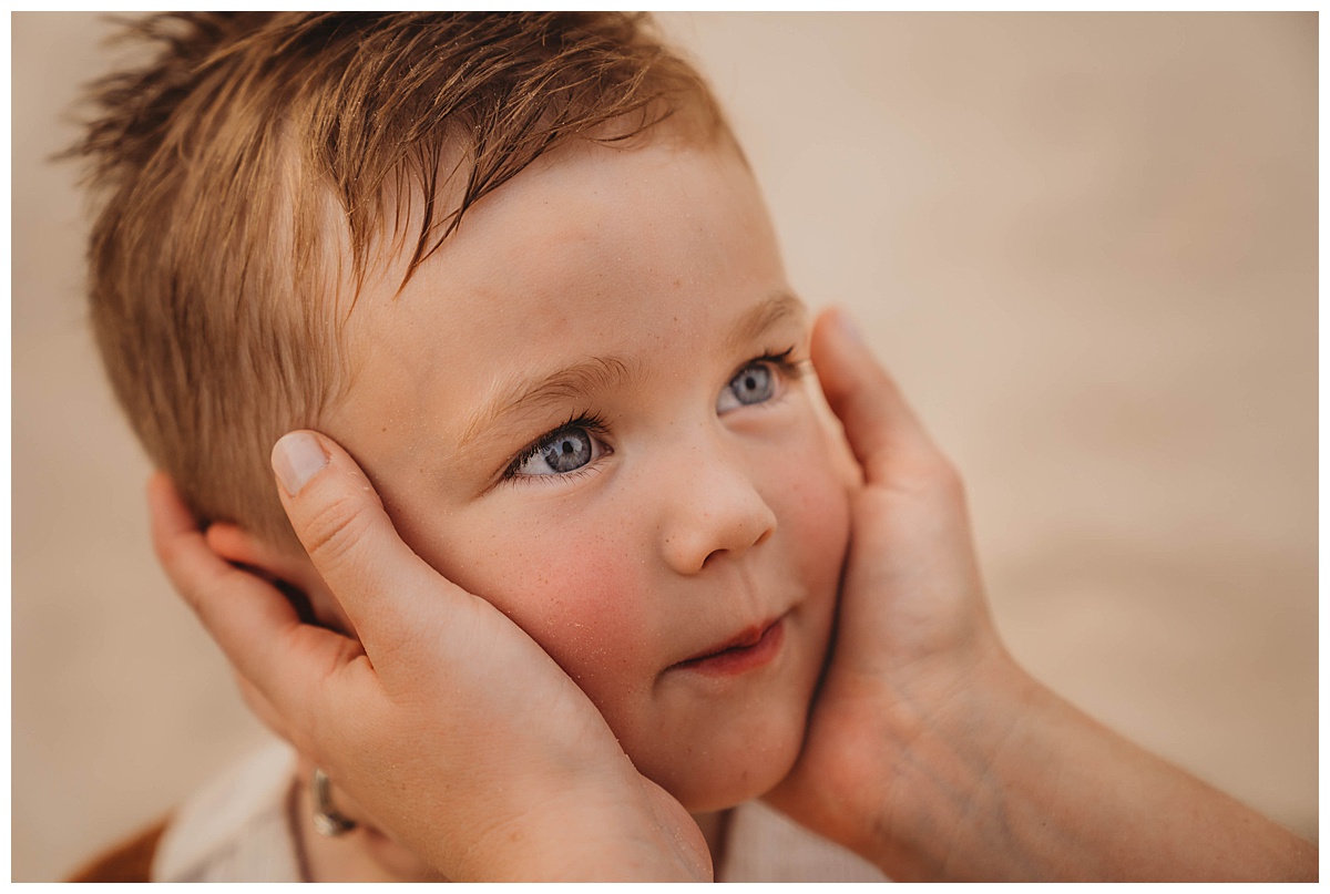 Young boy looks at his parents by Maria Grace Photos