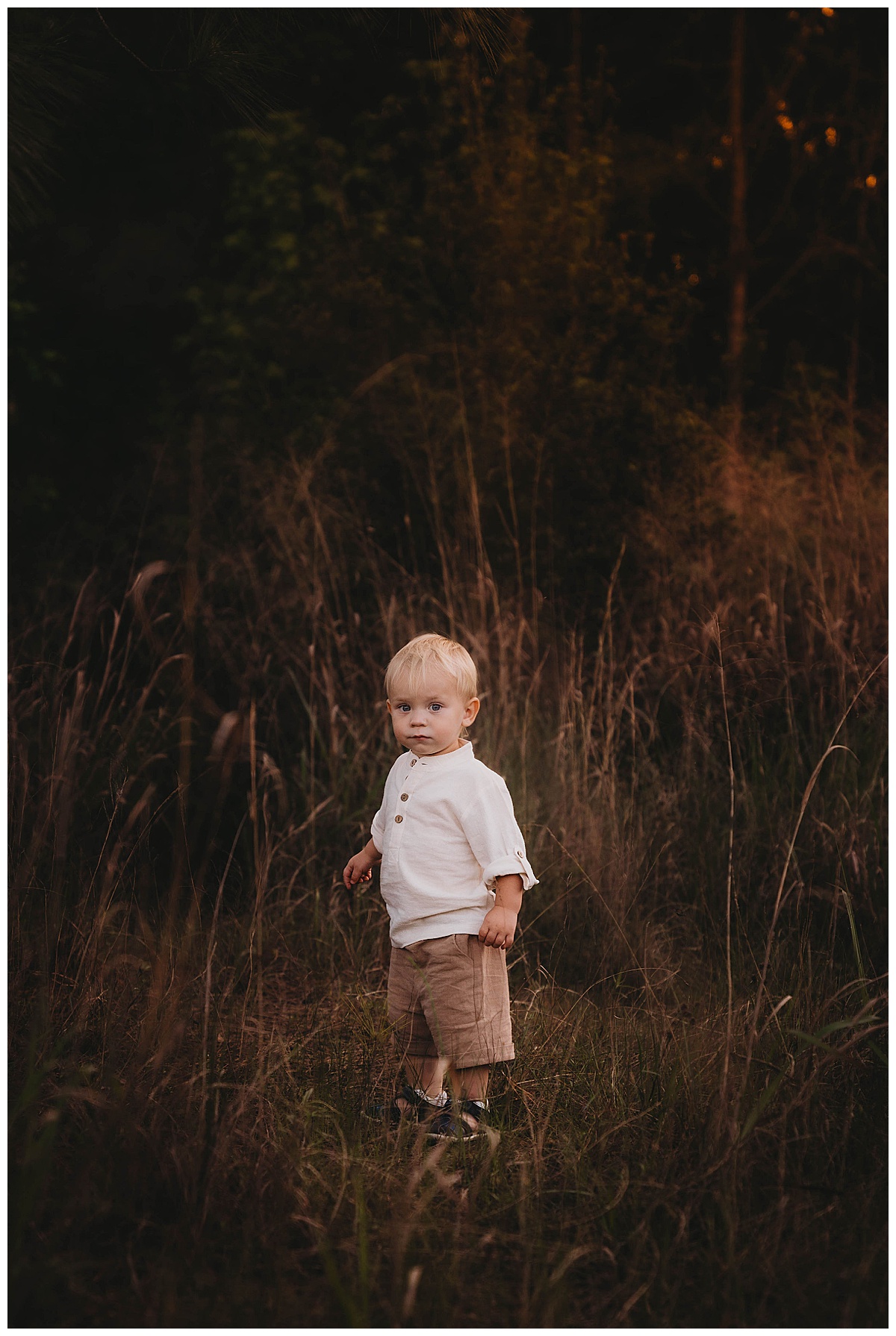 Young boy stands outside for The Woodlands Family Photographer