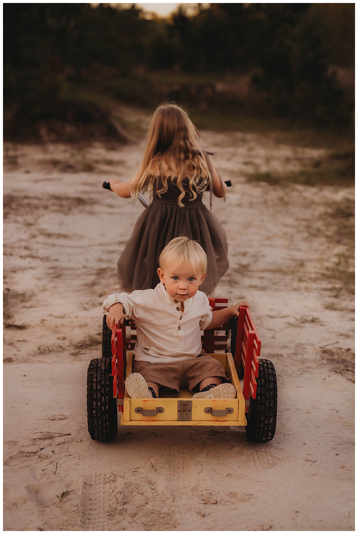 Sister pulls brother on wagon following my suggestion of Golden Hour for Family Photos