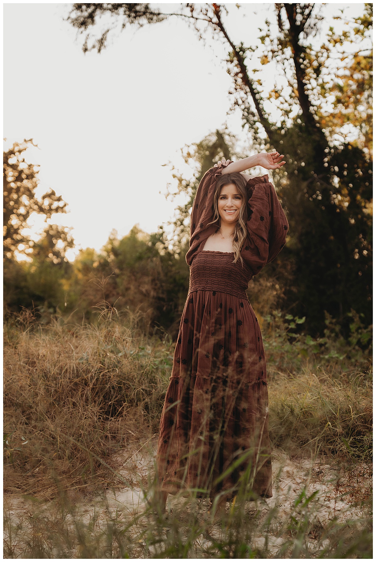 Woman poses with her hands above her head for The Woodlands Family Photographer