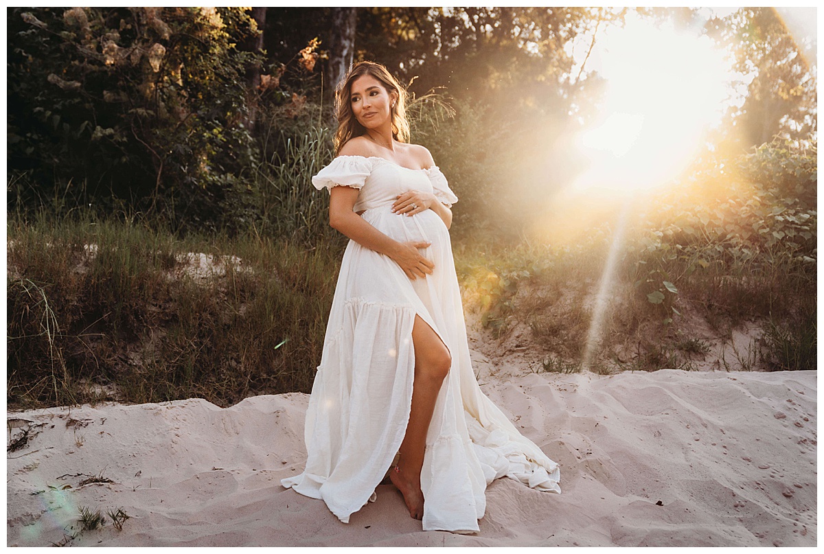 Woman embraces her pregnant belly for Maria Grace Photos