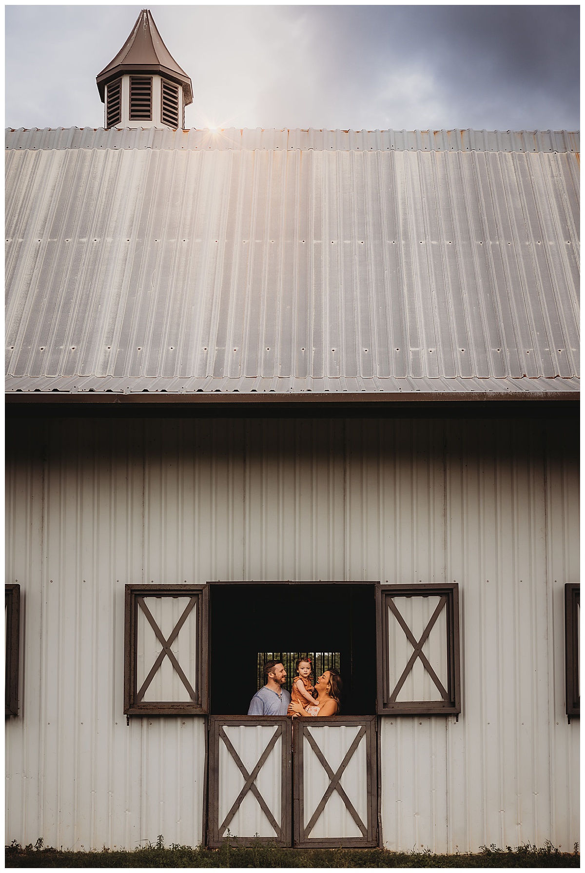 Family stand in window for The Woodlands Family Photographer