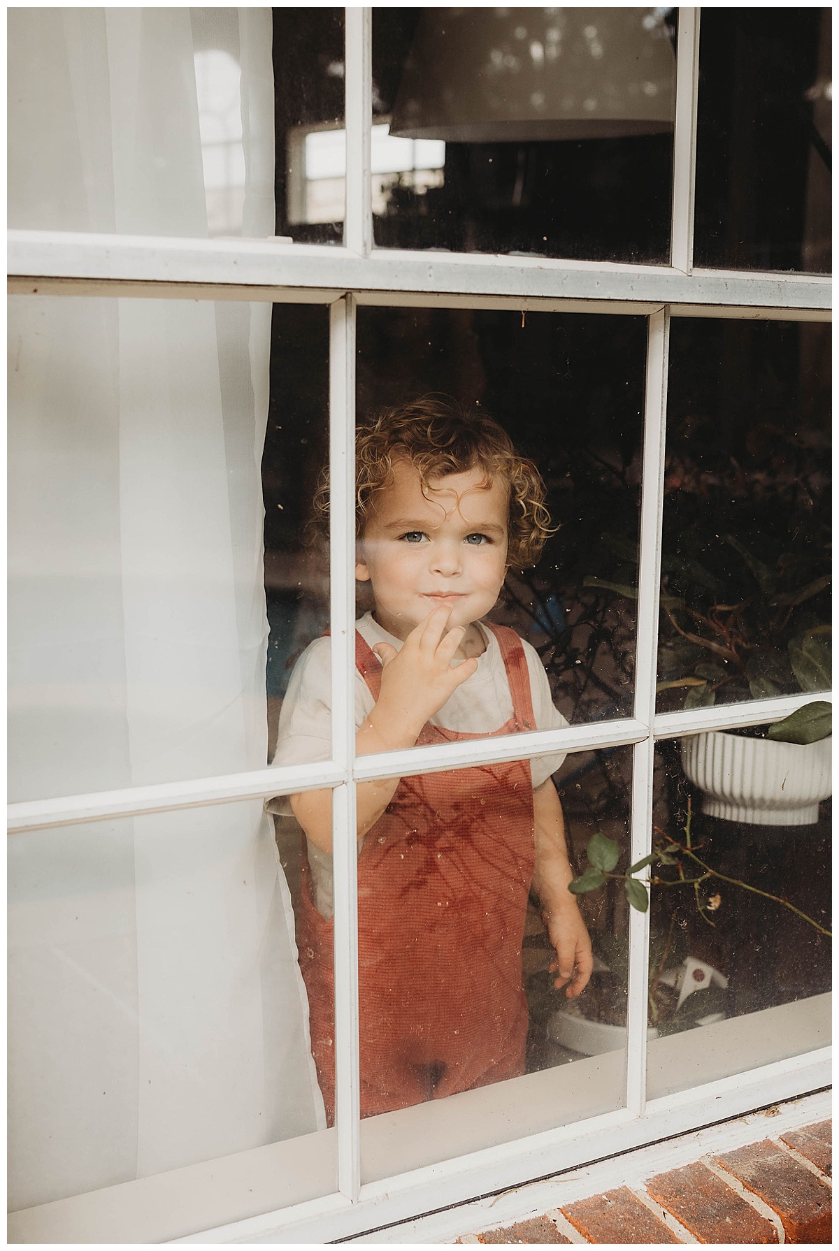 Young child looks out the window for Maria Grace Photos