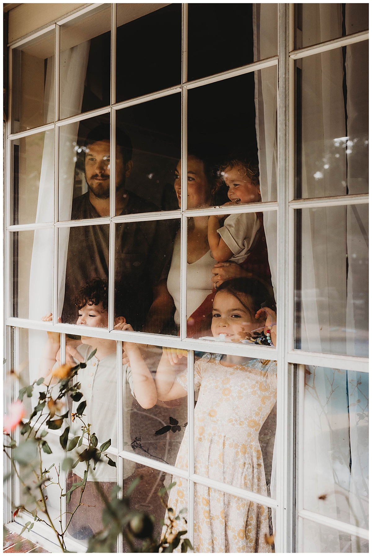 family looks out the window with a beautiful home showing How to Style Your Home for an In-Home Lifestyle Session