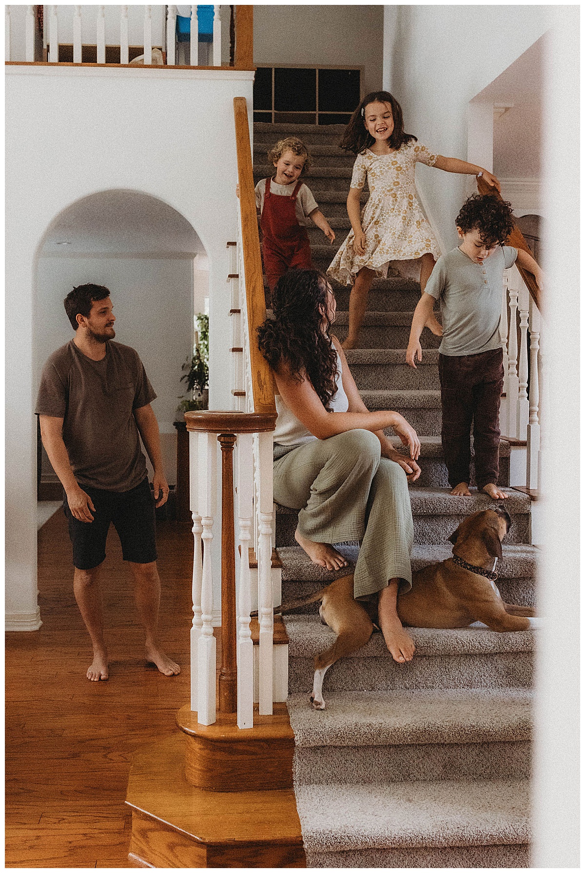 Family sit on the stairs together ina beautiful house showing How to Style Your Home for an In-Home Lifestyle Session