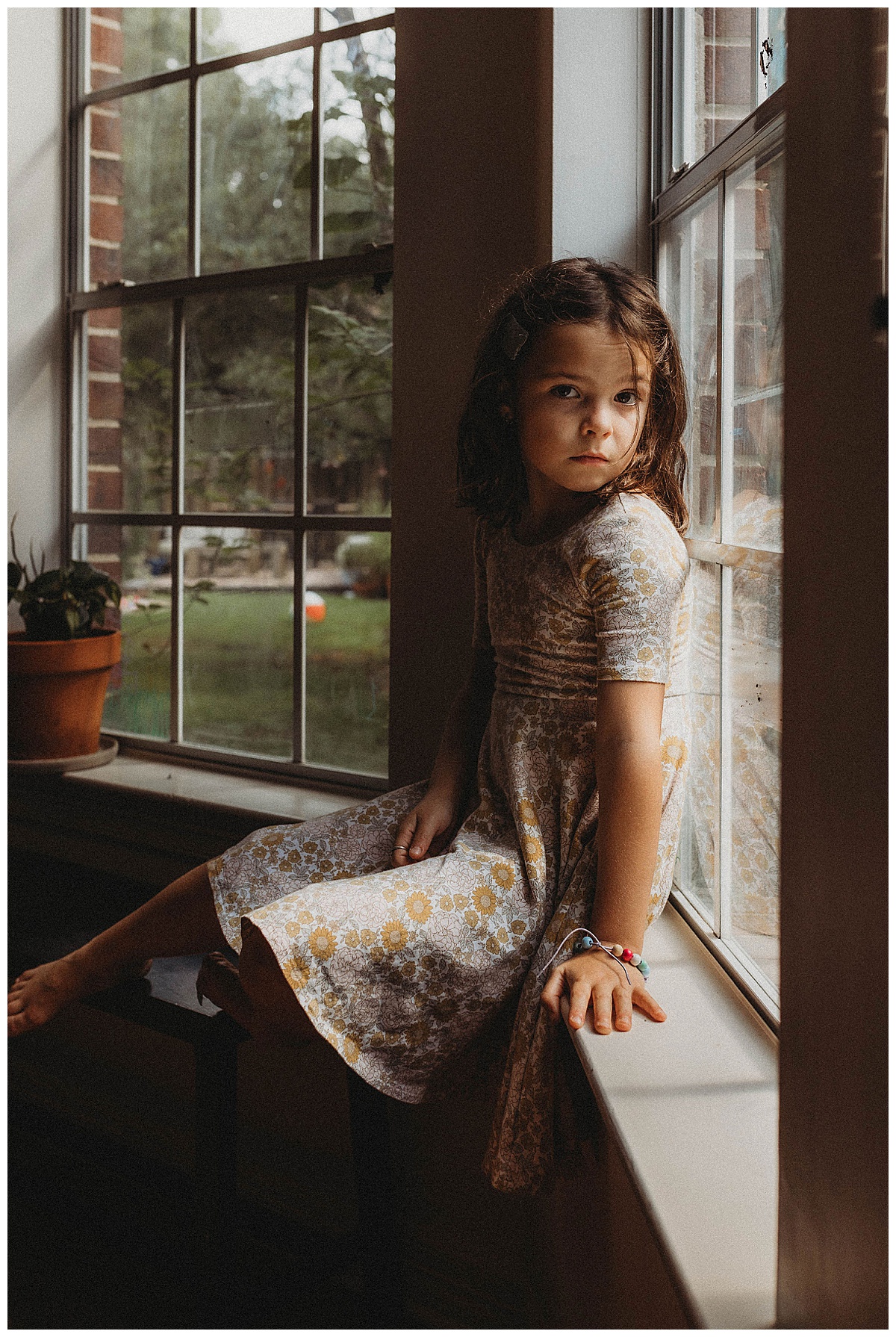 Young child sits against the window for Maria Grace Photos